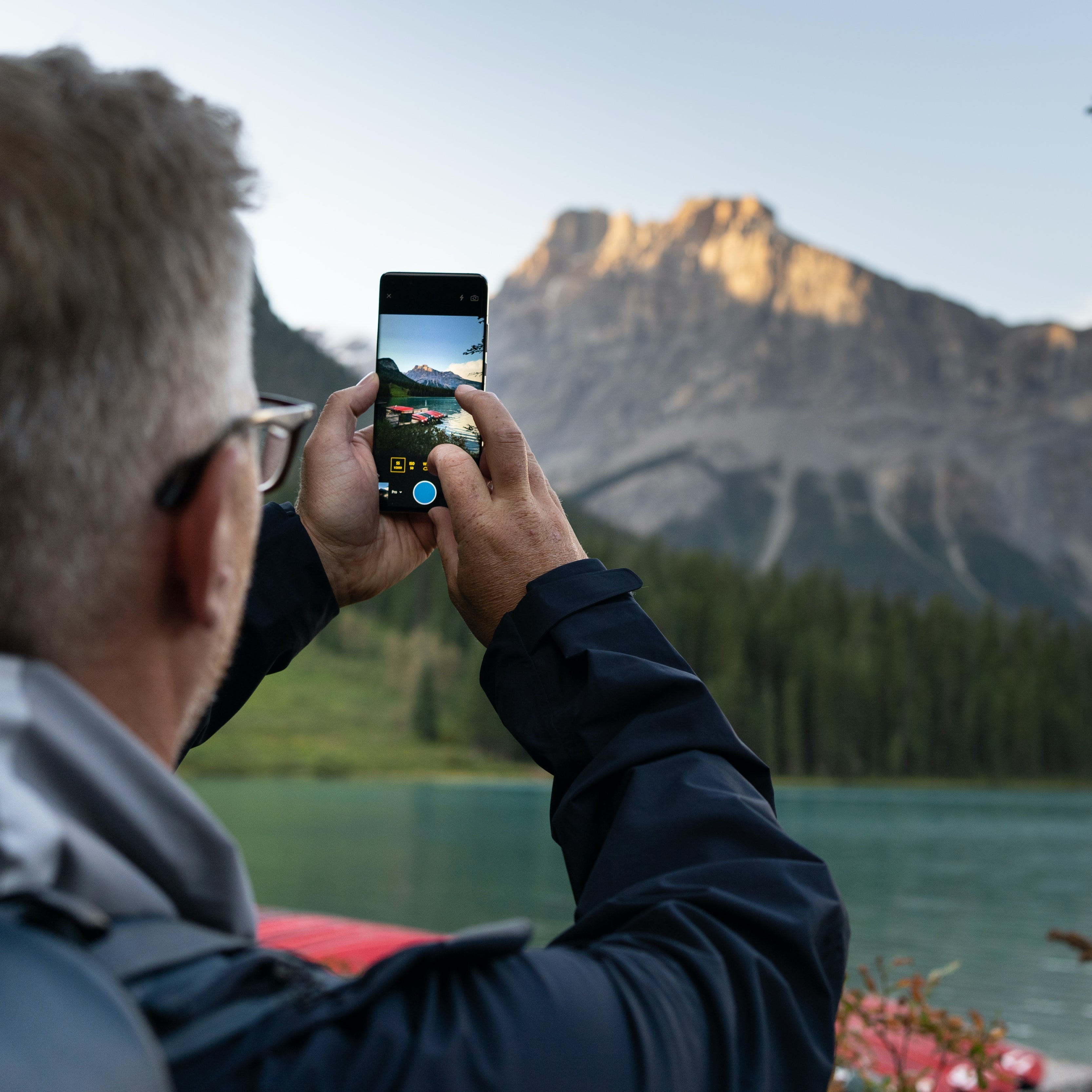 Man Taking a Photo of a Canadian Landscape Using His Smartphone