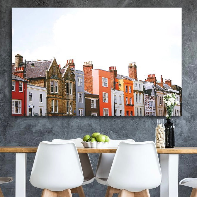 Photograph of Colourful Houses Printed on Metal and Displayed on a Wall Above a Table