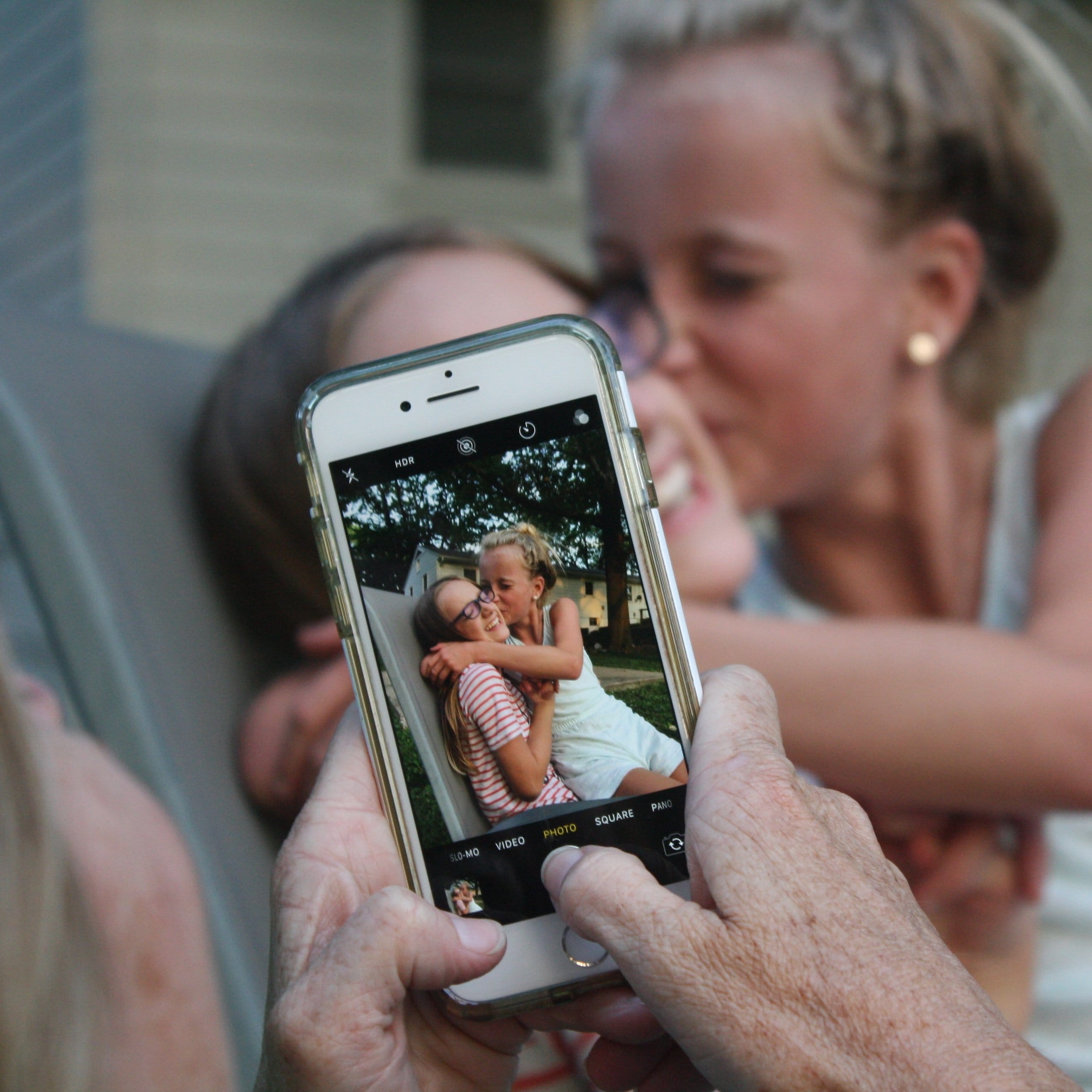 Person Capturing Photo of Siblings on iPhone