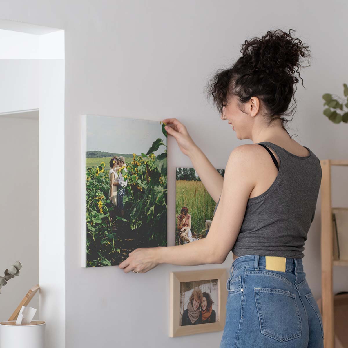 Person Hanging a Stretched Canvas Print on the Wall