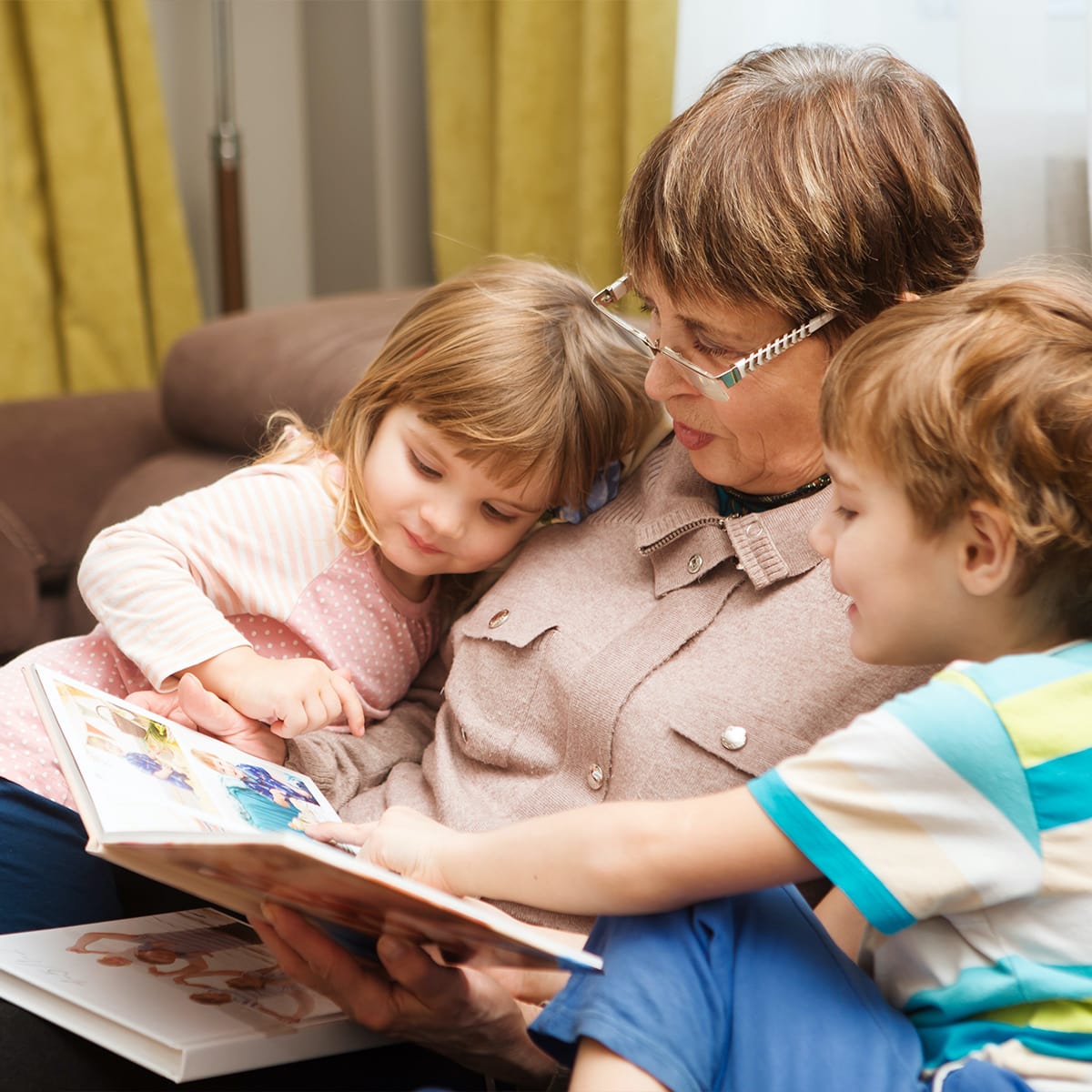 Grandmother looking at a photo book with grandchildren