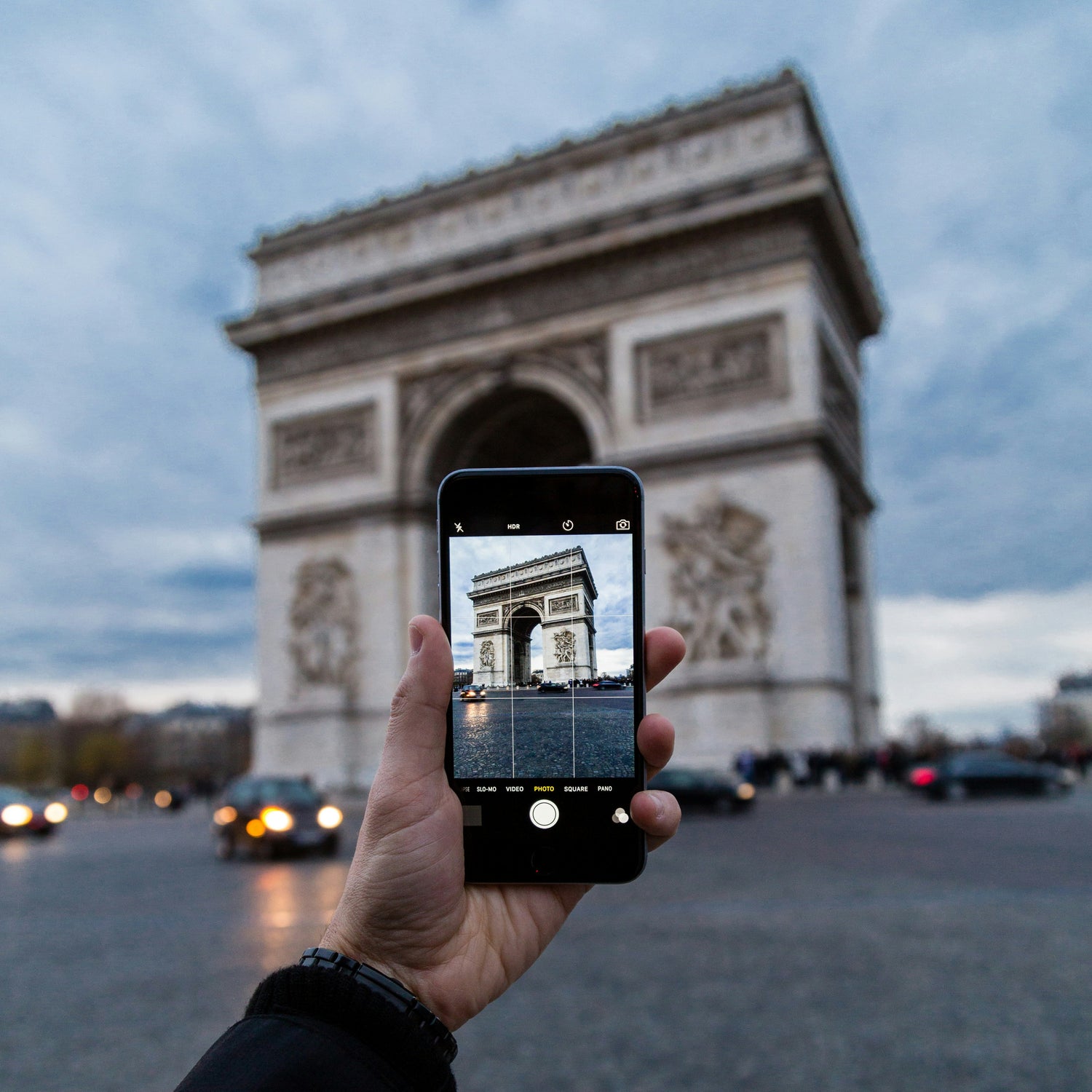 Person with smartphone taking a travel photo in Paris, France